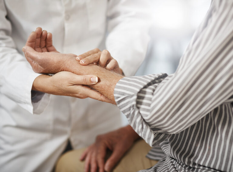 Cropped shot of an unrecognizable female doctor taking a male patients pulse during a consultation.