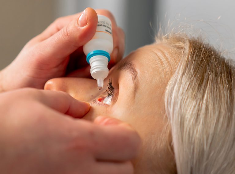 close-up in an ophthalmology clinic Freezing drops are put into a girl's eye